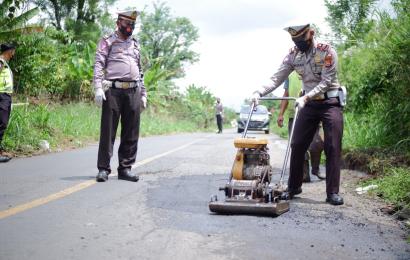 Polisi memperbaiki jalan rusak