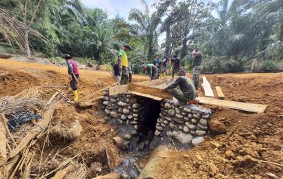 Satgas TMMD ke-114 Kodim 0423/BU Mengaduk Semen Untuk Pengecoran Gorong-Gorong