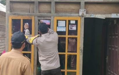 Bhabinkamtibmas Saat Dampingi Pemasangan Stiker Penerima Bansos.