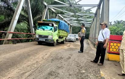 Bhabinkamtibmas Polsek Batik Nau Saat Mengatur Lalin  di Jembatan Desa Batik Nau