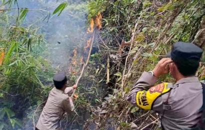 Bhabinkamtibmas Polsek Seginim Bantu Padamkan Kebakaran Lahan 