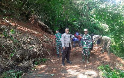 Bersama TNI dan Warga, Bhabinkamtibmas Bersihkan Material Longsor di Jalan Desa