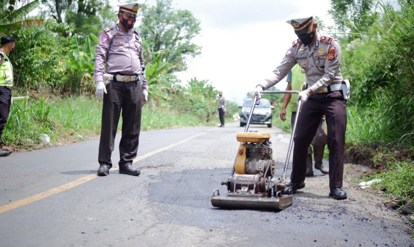 Polisi memperbaiki jalan rusak