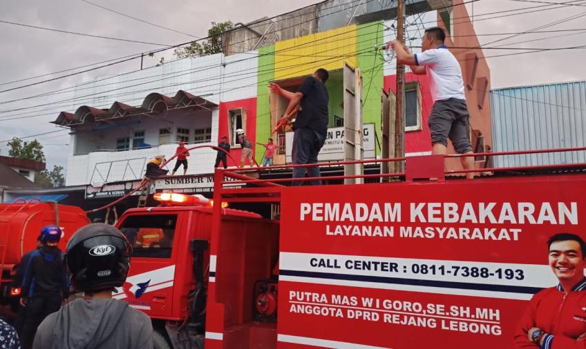 petugas dan warga saat membantu memadamkan api