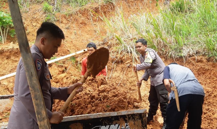 Bersama Warga dan Pemdes, Bhabinkamtibas Goro Membersihkan Material Tanah Longsor