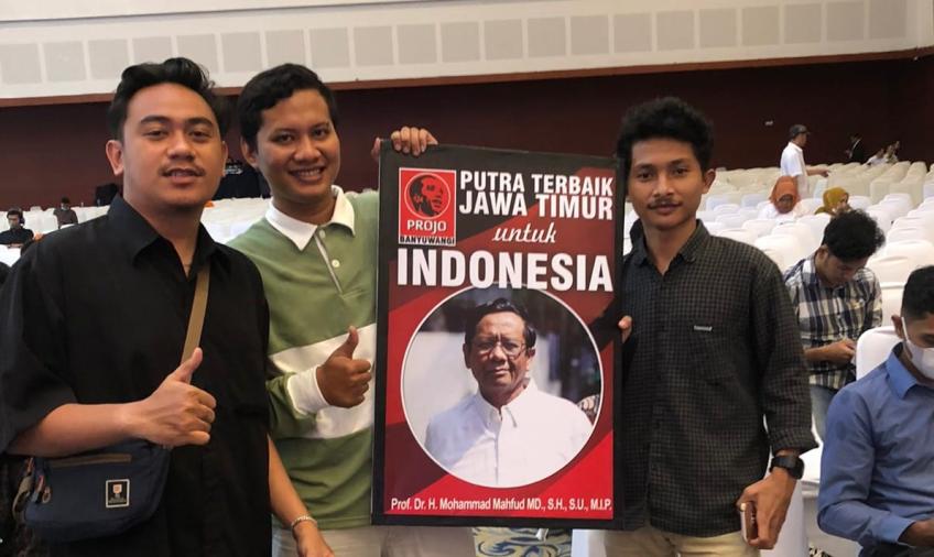 Salah satu relawan ProJo memegang spanduk bergambar Mahfud MD di Musyawarah Rakyat (Musra) ke-XIII Jawa Timur di Grand City Surabaya, Minggu (15/1)