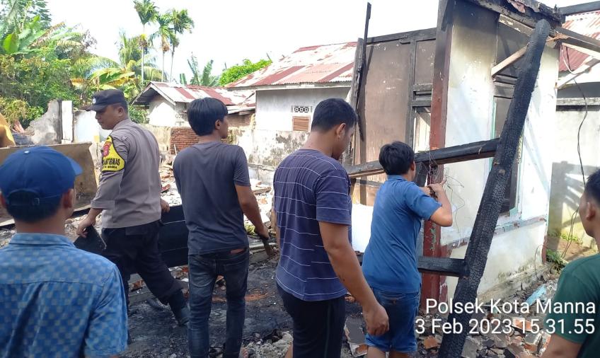 Bhabinkamtibmas Polsek Kota Manna Bantu Bersihkan Puing-Puing Rumah Warga Bekas Kebakaran