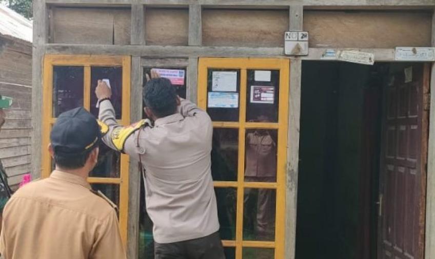 Bhabinkamtibmas Saat Dampingi Pemasangan Stiker Penerima Bansos.