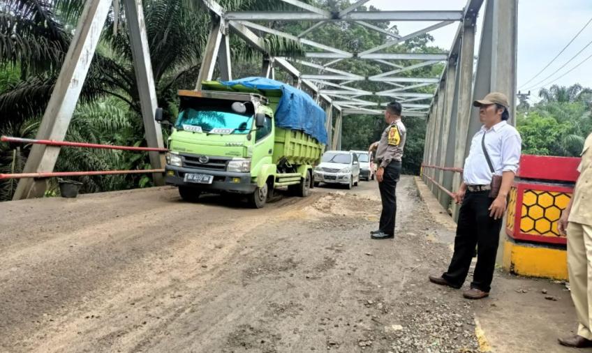 Bhabinkamtibmas Polsek Batik Nau Saat Mengatur Lalin  di Jembatan Desa Batik Nau