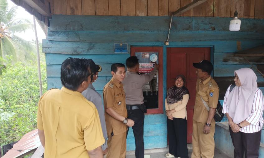 Bhabinkamtibmas Polsek Batik Nau Dampingi Tim Pendamping Desa Tempelkan Stiker di Rumah Warga