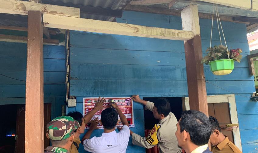 Bhabinkamtibmas Polsek Lais Dampingi Tim Tempelkan Stiker Penerima Bansos di Rumah Warga