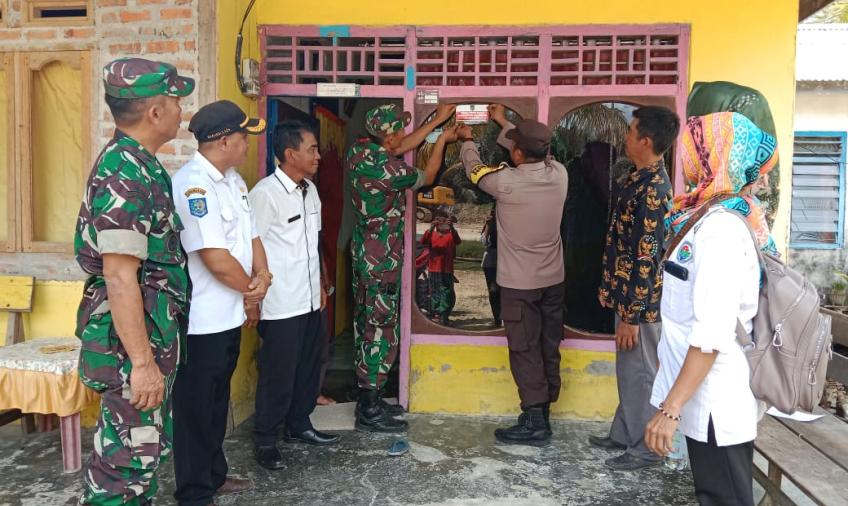 Bhabinkamtibmas Polsek Enggano Dampingi Pemerintah Desa Melakukan Penempelan Stiker di Rumah Warga Penerimaan BLT 