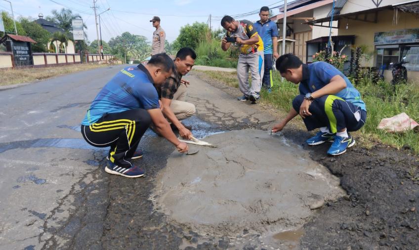 Peduli Keselamatan Masyarakat, Polsek Padang Jaya Tambal Jalan Berlubang Bersama Warga