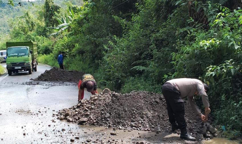 Sambang, Bhabinkamtibmas Polsek Rimbo Pengadang Bersihkan Material Longsor dan Timbun Jalan Berlubang