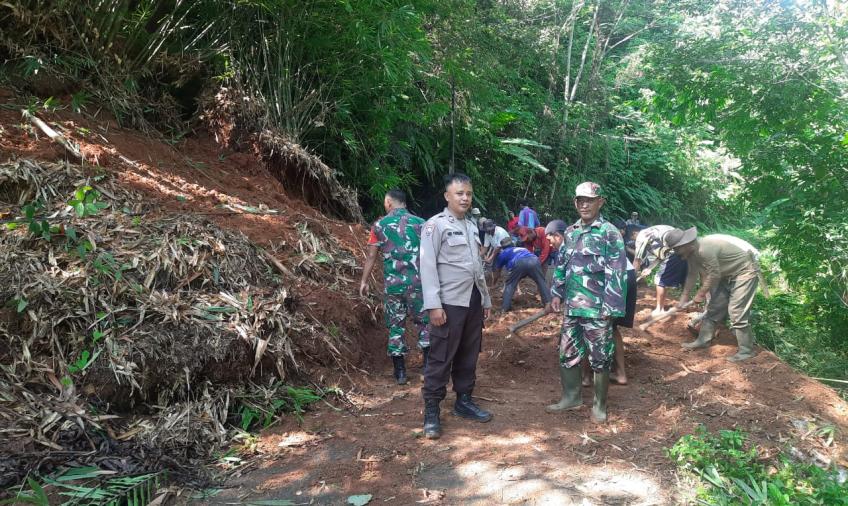 Bersama TNI dan Warga, Bhabinkamtibmas Bersihkan Material Longsor di Jalan Desa