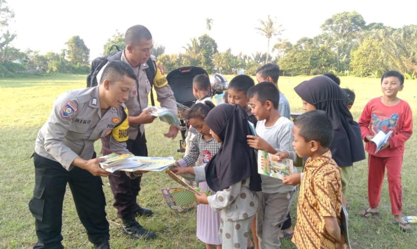 Tingkatkan Literasi, Bhabinkamtibmas Polsek Sindang Kelingi Bagikan Buku Bacaan Kepada Anak-anak