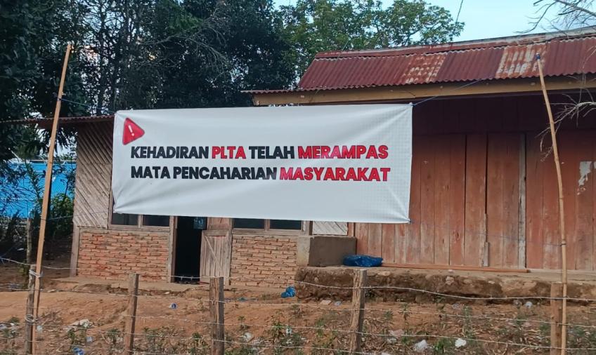 Spanduk bertuliskan Kehadiran PLTA Telah Merampas Mata Pencaharian Masyarakat yang di Bentangkan didepan Rumah Warga dan Proyek PLTA Kerinci, Jambi. Foto/Dok: Kolase Istimewa Neinews – Alfridho Ade Permana